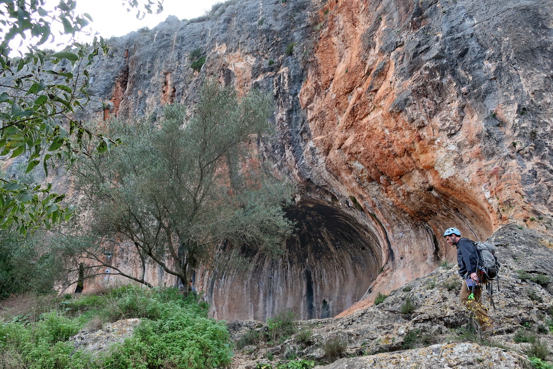 Climber with the prehistoric rock shelter Cova de la Petxina