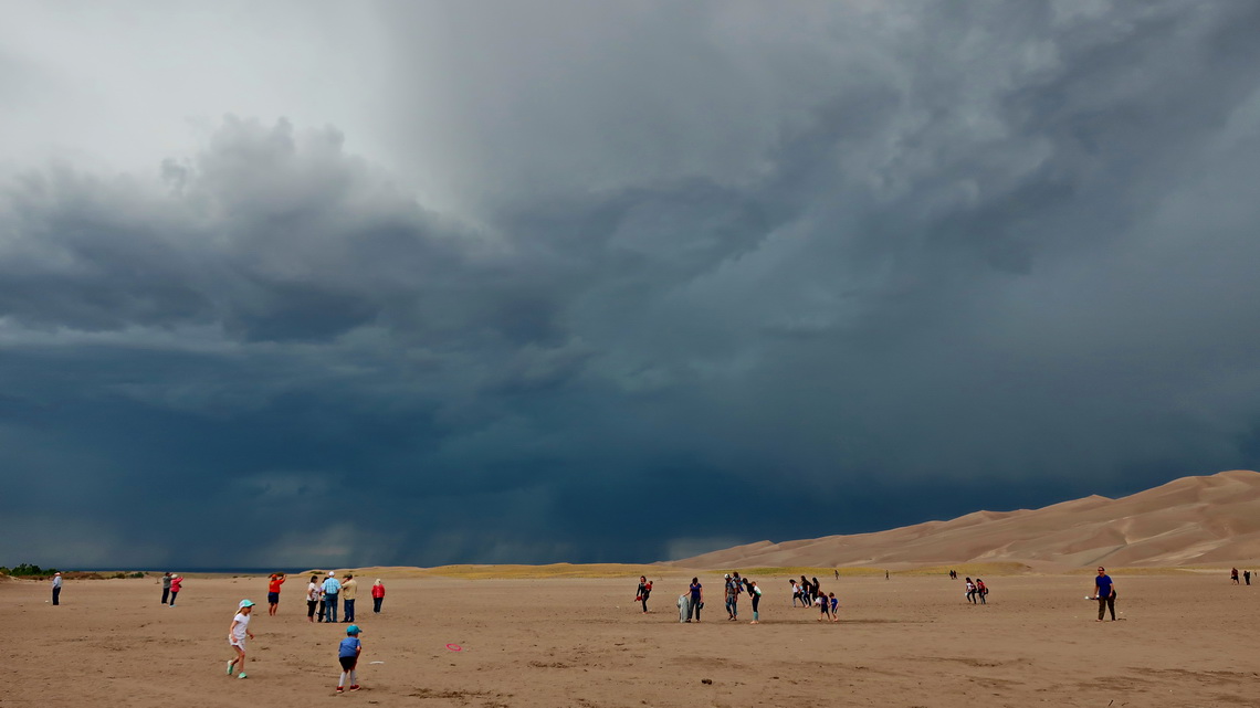 Crowded Great Sand Dunes with black clouds - thunder and lightning are coming!