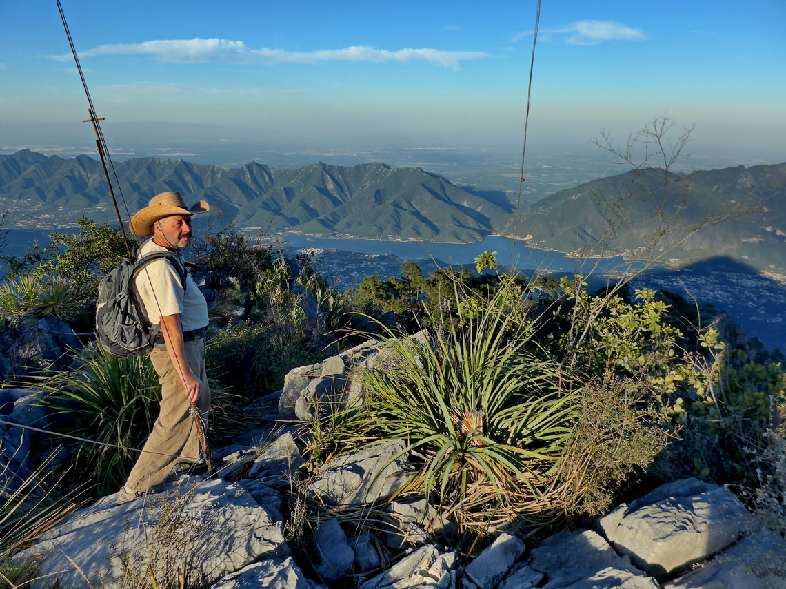 Tommy on the summit of 1847 meters high cerro Puerto Gringo with lake Presa Rodrigo Gomez