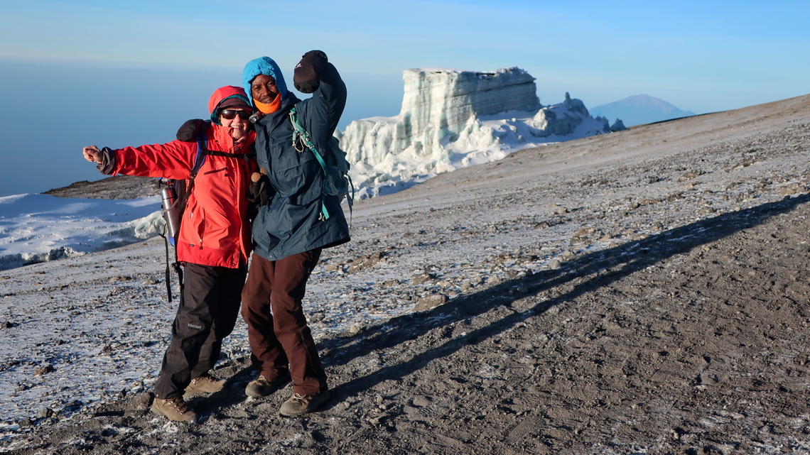 Happy Marion with one of our three guides and the ice of Kilimanjaro